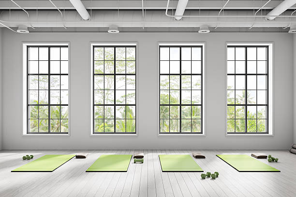 A bright home living room space cleared for a short movement session, yoga mat on the floor near a window